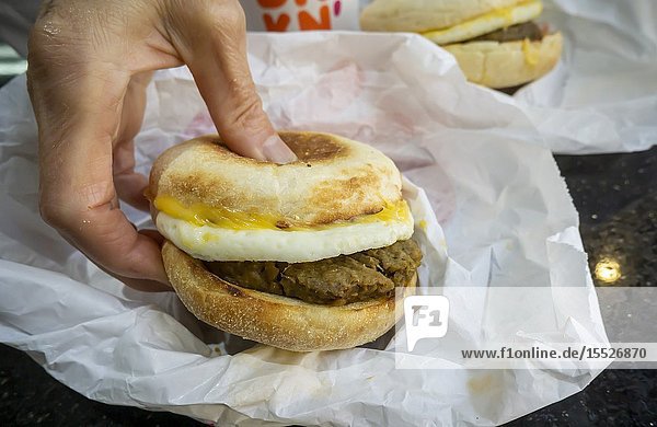A foodie grabs a plant-based breakfast sandwich made with Beyond Meat's vegan sausage in a Dunkin'restaurant in New York seen on Wednesday July 24 2019. The plant-based burger debuted today at select stores in New York. (© Richard B. Levine).