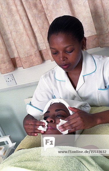 Beauty therapist giving a woman a facial