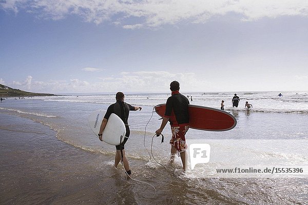 Surfers caring surf boards on the beach