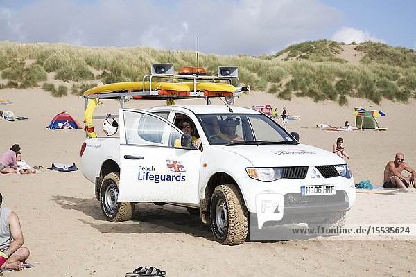 RNLI Lifeguard in his vehicle on the beach