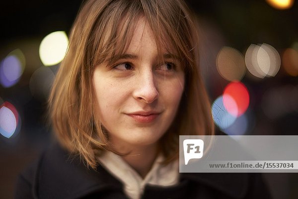 Woman peering aside at night in Berlin Germany
