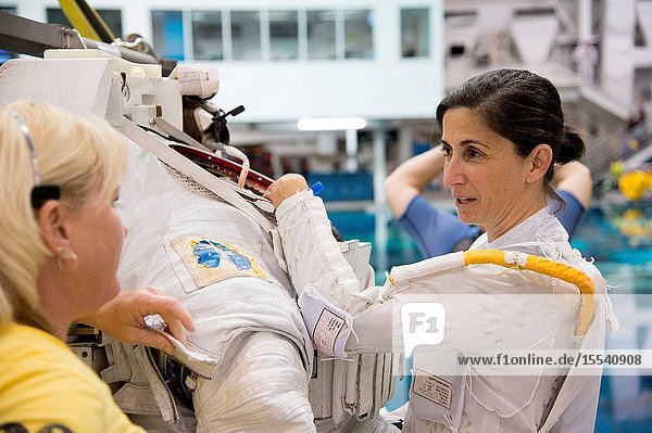 NASA astronaut Nicole Stott prepares for a spacewalk training session in the waters of the Neutral Buoyancy Laboratory (NBL) near NASA's Johnson Space Center. Stott is wearing a liquid cooling and ventilation garment that complements the Extravehicular Mobility Unit (EMU) spacesuit. A crew instructor assisted Stott.