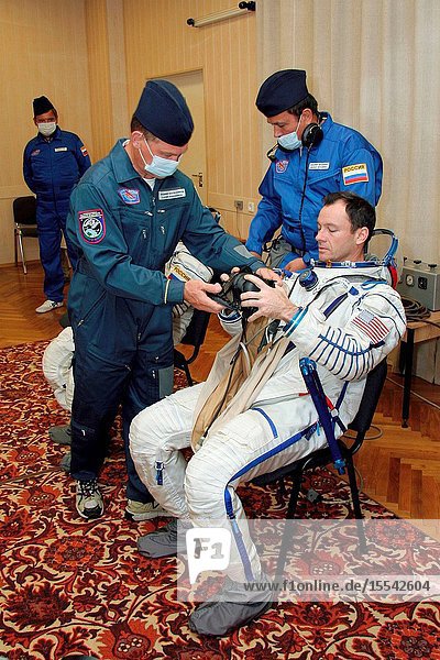 Astronaut Michael E. Lopez-Alegria  Expedition 14 commander and NASA space station science officer  dons his pressure suit at building 254 of the Baikonur Cosmodrome  Baikonur  Kazakhstan prior to launch onboard the Soyuz. Technicians assisted Lopez-Alegria. Photo credit: Victor ZelentsovNASA.