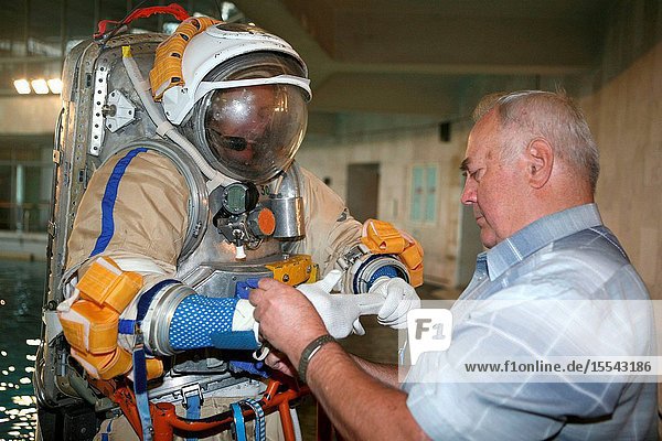 Astronaut Michael E. Lopez-Alegria  Expedition 14 commander and NASA space station science officer  gets help with final touches on the training version of his Russian Orlan spacesuit prior to an underwater spacewalk simulation in the Hydrolab facility at the Gagarin Cosmonaut Training Center in Star City  Russia.
