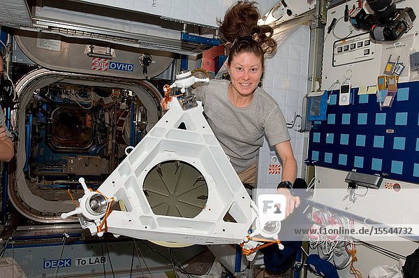 NASA astronaut Tracy Caldwell Dyson  Expedition 23 flight engineer  poses for a photo while holding Power and Data Grapple Fixture (PDGF) hardware in the Harmony node of the International Space Station.