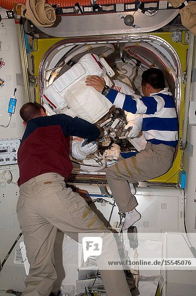 Astronaut Tony Antonelli (left) STS-119 pilot and Japan Aerospace Exploration Agency (JAXA) astronaut Koichi Wakata Expedition 18 flight engineer assist astronaut Steve Swanson and Joseph Acaba (out of frame) both STS-119 mission specialists as they return to the Quest Airlock of the International Space Station as the mission's second session of extravehicular activity (EVA) draws to a close.