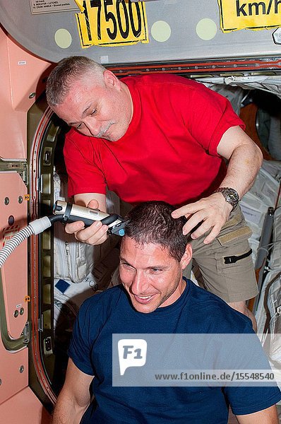 Russian cosmonaut Fyodor Yurchikhin Expedition 37 commander trims the hair of NASA astronaut Michael Hopkins flight engineer in the Unity node of the International Space Station. Yurchikhin used hair clippers fashioned with a vacuum device to garner freshly cut hair.