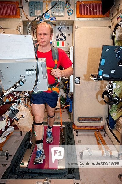 Russian cosmonaut Oleg Kotov Expedition 37 flight engineer equipped with a bungee harness exercises on the Treadmill Vibration Isolation System (TVIS) in the Zvezda Service Module of the International Space Station.