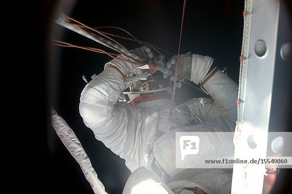 Close-up view of Skylab 2 crew member Joseph P. Kerwin clearing away the remnants (cables and tubing) from the missing solar array panel during an early mission tethered extravehicular activity (EVA) to repair the damaged and partially deployed solar array panel. Conrad's life support umbilical is seen cutting diagonally across the image next to Kerwin. After the successful EVA the solar panel was fully deployed.