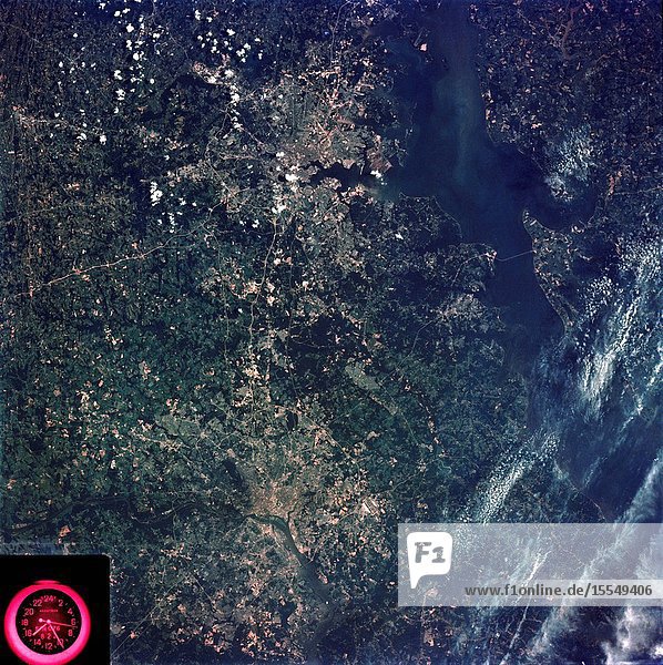 A vertical view of the Washington D.C. and the Baltimore Maryland area is seen in the Skylab 3 Earth Resources Experiments Package S190-B (five-inch Earth terrain camera) photograph taken from the Skylab space station in Earth orbit. The Chesapeake Bay is on the right (east) side of the picture. The Potomac River flows through the Washington area in the lower left (southwest) corner of the photograph. Several transportation routes and major highways stand out very distinctly. Especially conspicuous are the beltways around the cities Interstate 95 between Baltimore and the nation's capitol and Interstate 70N leading west from Baltimore. The tunnel and harbor facilities in Baltimore show clearly also. Identifiable features in the Washington area include the Capitol Building the Mall area Robert F. Kennedy Stadium (white circle) the five bridges across the Potomac Andrews Air Force Base (on east loop) and the smaller Anacostia River. The extent of the urbanization in this area is dramatically illustrated in this picture. The photograph has sufficient resolution that the housing patterns for individual suburban areas are clearly defined with the houses shown as pink gray wooded areas as dark green and cleared areas light green. Chesapeake Bay circulation patterns are indicated by contrast of dark and light blue. Sediment plumes (red) are seen entering the bay north and east of Baltimore. The bay bridge stands out white against the blue water. The detailed information contained in this one photograph will be of direct use to several EREP investigator teams in land use analysis sedimentation and circulation patterns in the bay and resource surveys of Maryland. All EREP photography is available to the public through the Department of Interior's Earth Resources Observations Systems Data Center Sioux Falls South Dakota 57198.