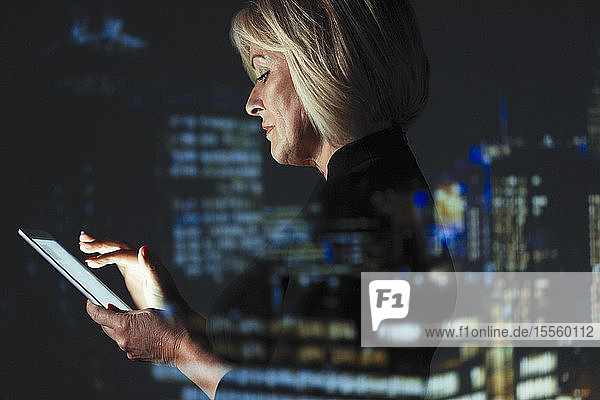 Doppelbelichtung Geschäftsfrau mit digitalen Tablette gegen Hochhaus Lichter in der Nacht