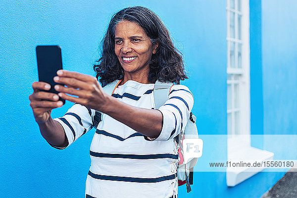 Glückliche Touristin macht Selfie mit Smartphone