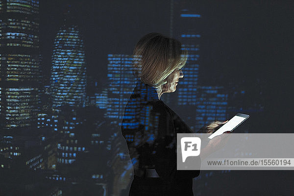 Doppelbelichtung Geschäftsfrau mit digitalen Tablette gegen Hochhaus Lichter in der Nacht