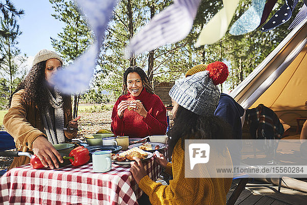 Familie beim Essen am Picknicktisch auf dem Campingplatz