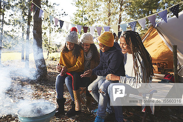 Glückliches lesbisches Paar und Kinder entspannen sich auf einem Campingplatz im Wald