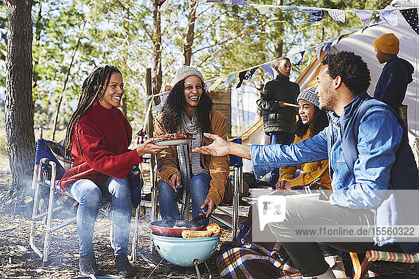 Glückliche Familie beim Essen auf dem sonnigen Campingplatz