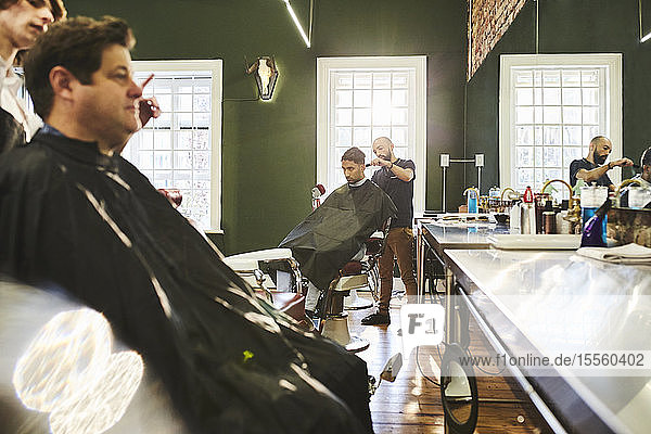 Männliche Kunden und Friseure im Friseursalon