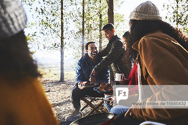 Glückliche Familie beim Essen auf dem sonnigen Campingplatz