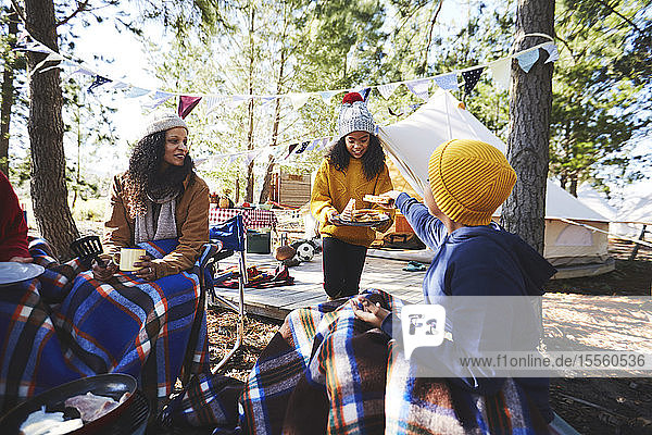 Familie beim Essen auf einem Campingplatz im Wald