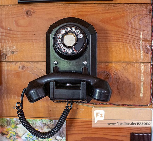 A rotary dial telephone is still in use.