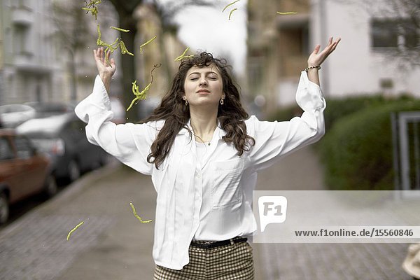 Young woman tossing inflorescences in the air Berlin Germany.