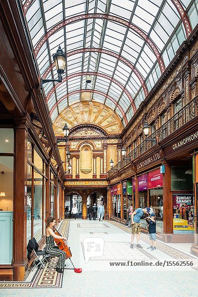 Female busker playing Chello in The Central Arcade in Newcastle upon Tyne England UK. Central Arcade is an Edwardian shopping arcade built in 1906.