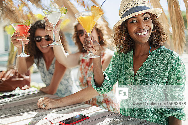 Porträt glückliche Frauen Freunde mit Cocktails am sonnigen Strand bar