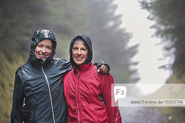 Portrait mother and daughter hiking in rain