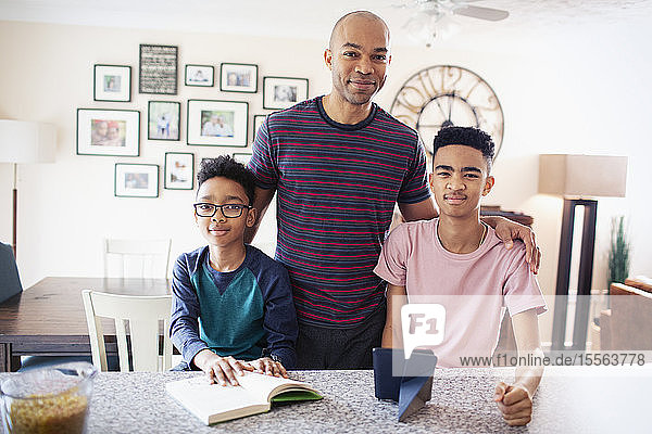 Portrait confident father and sons in kitchen