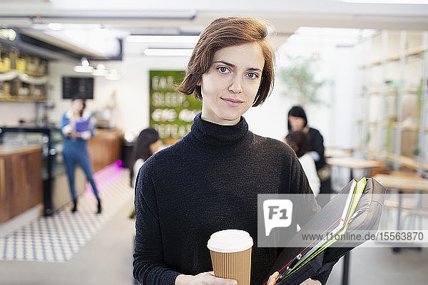 Portrait confident businesswoman with coffee in office