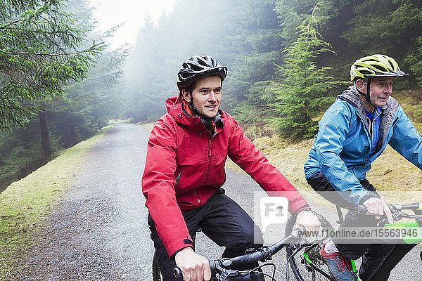 Vater und Sohn beim Mountainbiking im Wald