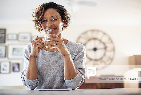 Porträt lächelnde  selbstbewusste Frau beim Teetrinken