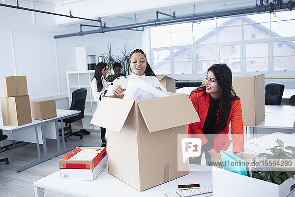 Businesswomen unpacking  moving into new office