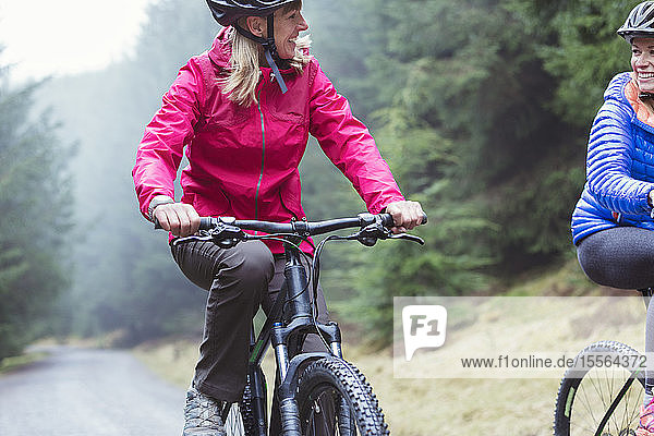 Women mountain biking in woods