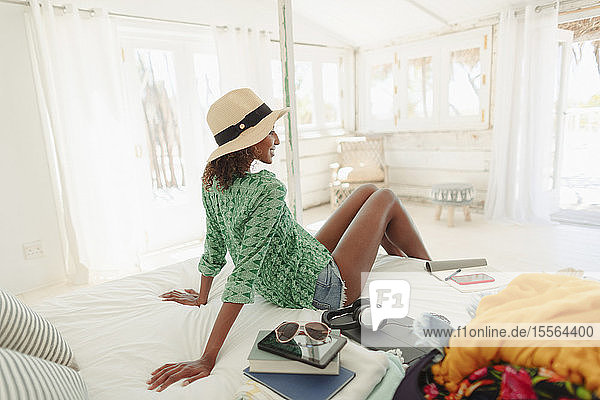 Frau entspannt sich auf dem Bett einer Strandhütte