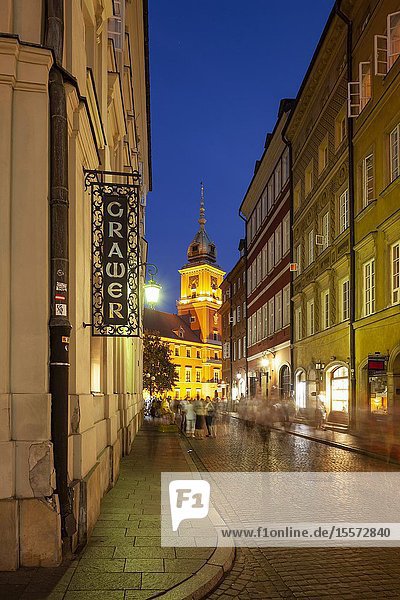 Evening in Warsaw old town Poland. Royal Castle tower in hte distance.