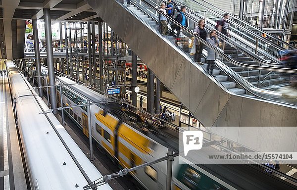 Passengers  and a train arriving at a platform inside the main train station (Hauptbahnhof)  Berlin  Germany.