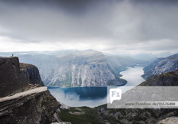 View of Trolltunga cliff and lake between mountains picturesque landscape beauty in nature paradise on Earth sunny day Odda Norway. cloudy day.