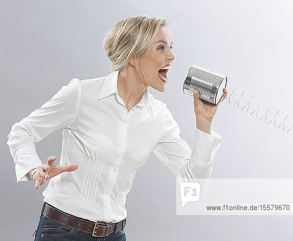 Business woman shouting into tin can