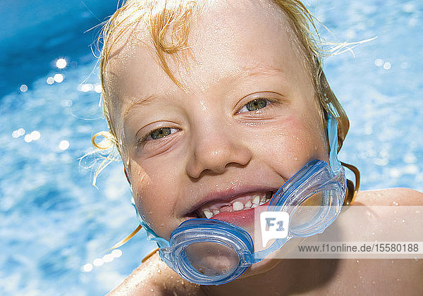 Deutschland  Junge mit Schwimmbrille  Porträt  lächelnd
