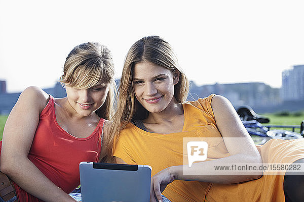 Germany  Cologne  Young woman using digital tablet  smiling