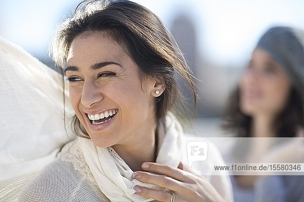 Porträt einer lachenden Frau mit weißem Schal