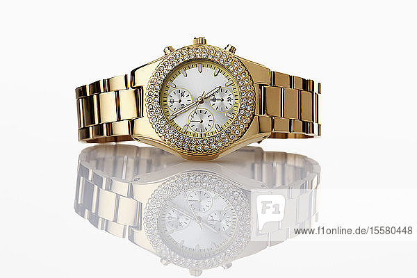 Goldene Armbanduhr mit Juwelen auf weißem Hintergrund