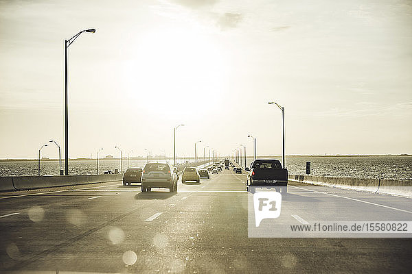Autos bewegen sich auf der Autobahn über dem Meer gegen den Himmel bei Sonnenuntergang  Miami  USA