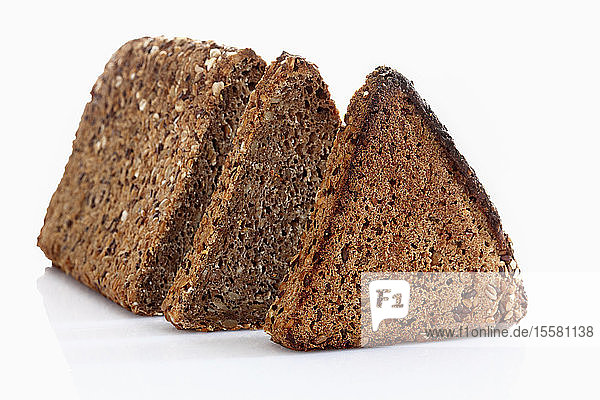 Mehrkornroggenbrot mit Scheibe auf weißem Hintergrund  Nahaufnahme