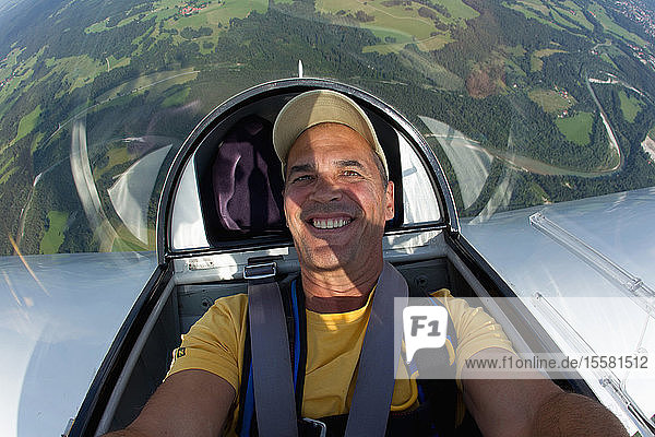 Deutschland  Bayern  Bad Tölz  Reifer Mann im Segelflugzeug  lächelnd  Porträt