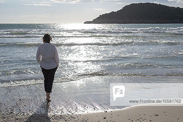 Griechenland  Parga  Frau steht im Gegenlicht an der Strandpromenade
