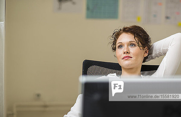 Young woman in office thinking