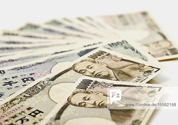 Japanische Yen-Scheine vor weissem Hintergrund aufgefächert