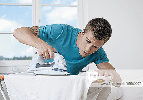 Germany  Augsburg  Man ironing shirt